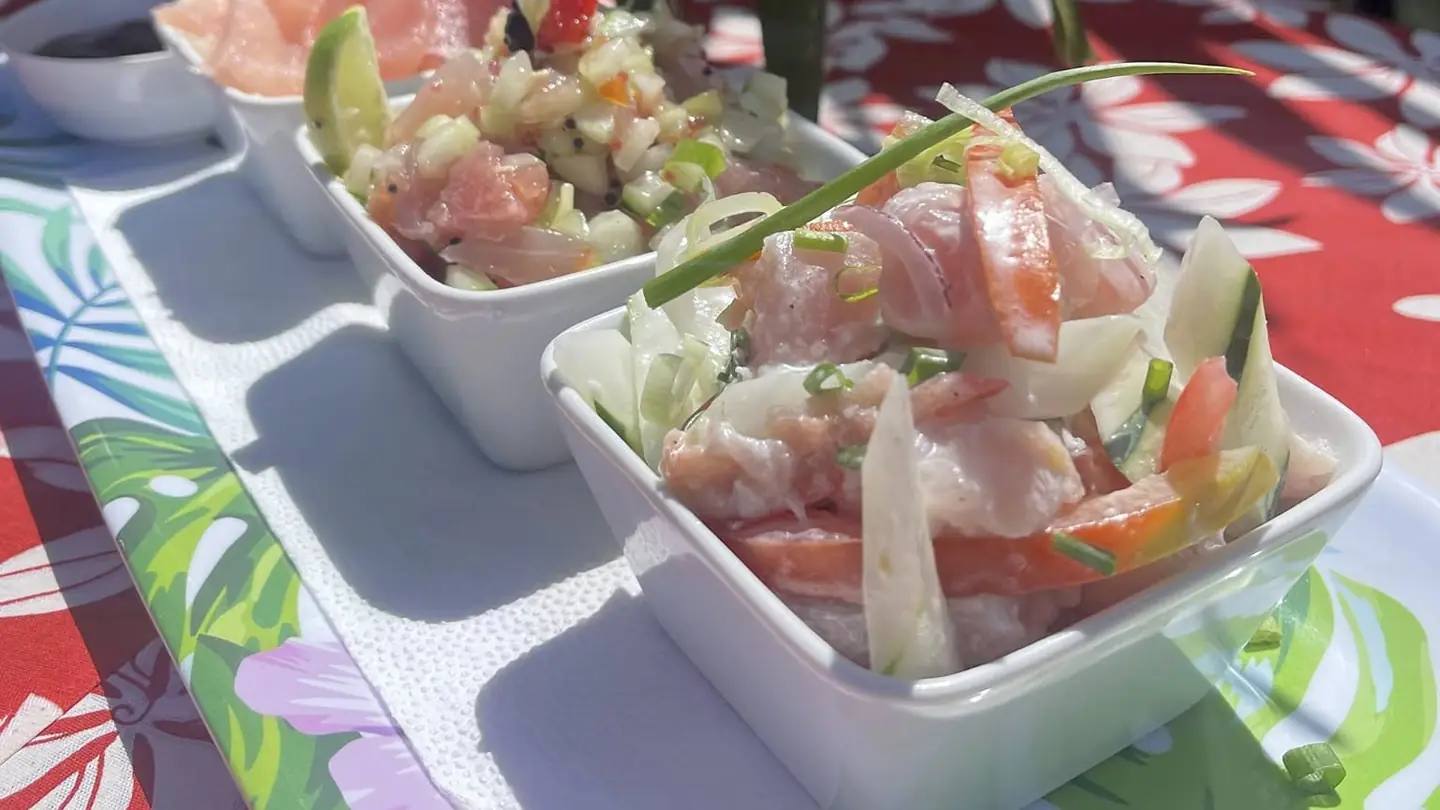 Trilogie de poisson servie sur une nappe à fleurs de tiare